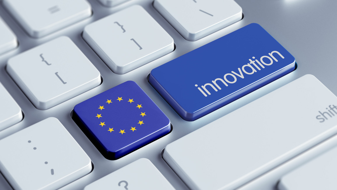 Nahaufnahme einer hellen Computertastatur. Zwei Tasten sind in blau hervorgehoben: Auf einer ist die Europaflagge zu sehen, auf der anderen steht das Wort „Innovation“.